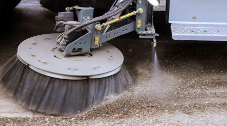 Street sweeper machine cleaning patch of concrete